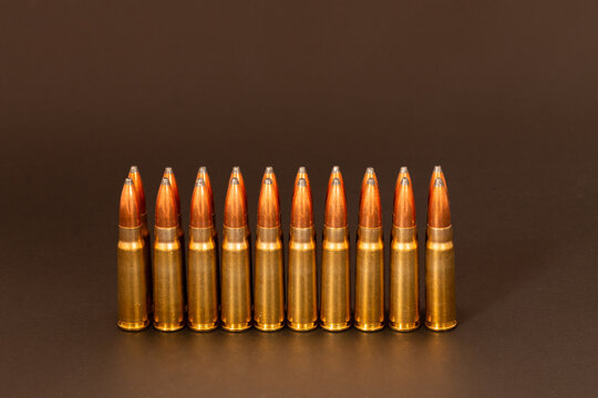 7.62x39 ammunition, hunting rounds, rifle cartridges with soft point bullets standing upright in two rows against a dark background..
