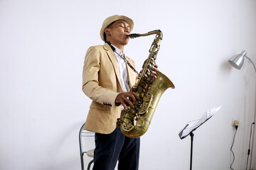 Young Male Playing Saxophone Isolated On White Background 
