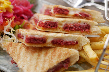 Savory sandwiches served with fries and fresh salad garnish.,