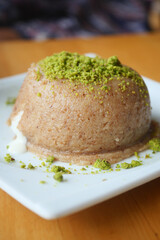Creamy sweet dish garnished with crushed pistachios..