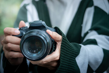 A female photographer who is preparing to take photos in a forest park