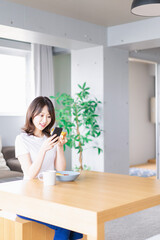 自宅で朝食を食べる若い女性