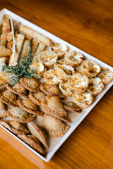 Delicious assortment of savory pastries and snacks on a wooden table during a festive gathering
