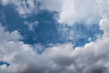 Stunning cloudscape image featuring fluffy white and grey clouds against a vibrant blue sky.  Natural light, outdoor scene.