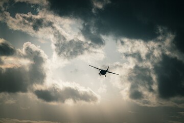A propeller plane flying through the clouds on a morning after rain
