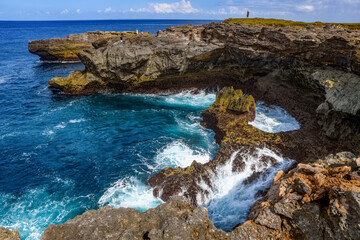 Waves crash into a rocky tropical bay