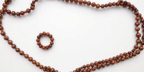 Obraz premium Overhead view of handmade ring featuring brown beads on a plain white surface, jewelry display, product presentation, ring details