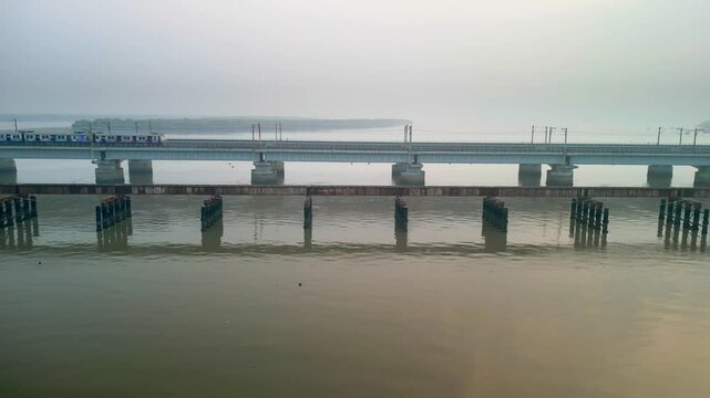train going from naigoan to bhayandar on vasai creek bridge side closeup drone view