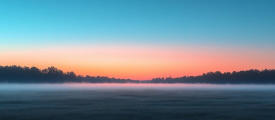 Fototapeta premium Misty sunrise over a tranquil field, pastel sky colors.