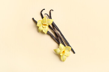 Aromatic vanilla sticks with flowers on color background