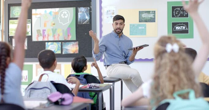 Young Asian man teaches in a vibrant classroom at school