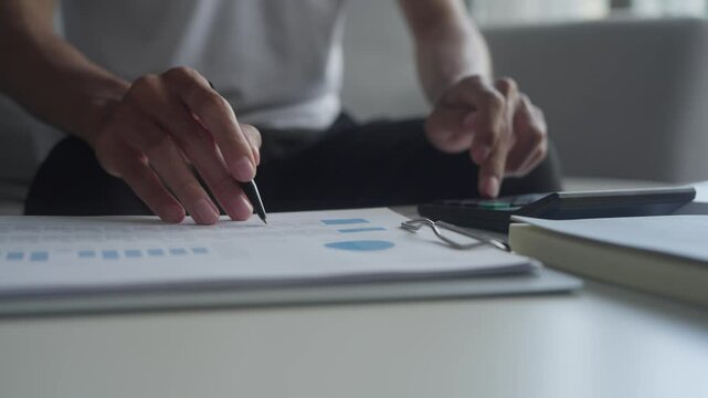 Man calculates finances by calculator pay bills taxes financial at home.