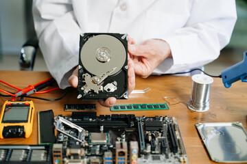 Obraz premium Technician repairing inside of hard disk drive by screwdriver. the concept of data, hardware, technician