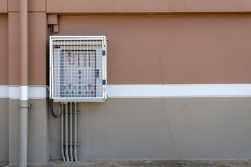 A securely mounted electrical control cabinet with external conduits installed on the building&rsquo;s outer wall, ensuring safe and efficient power distribution in an industrial or commercial setting.