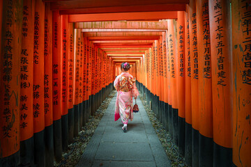 Japanese women in a traditional Japanese kimono walks at Fushimi Inari Shrine in Kyoto. landmarks of Japan 