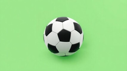 classic black and white soccer ball positioned on a bright green background. The soccer ball features the traditional hexagonal pattern, with alternating black and white panels.