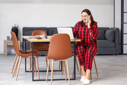Young businesswoman working at table in office. National Wear Your Pajamas to Work Day