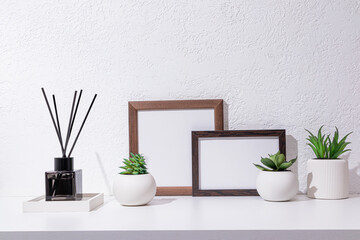Home interior with decor elements. Mockup with a wooden frame, on a light background. Front view. Minimalist style. diffuser with incense sticks.
