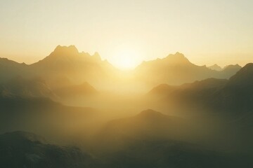 Fototapeta premium Blurry background of a mountain range at sunrise, the first rays of light illuminating the peaks through a hazy fog