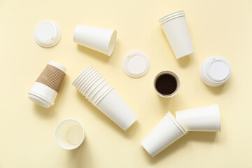 White disposable cups of coffee on yellow background