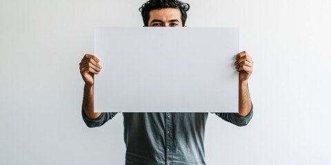 A man is holding a blank white sign