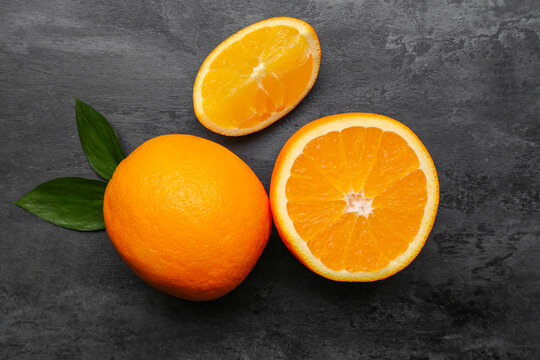 Fresh ripe oranges and leaves on black background - Powered by Adobe