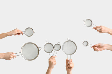 Female hands with sieves on white background