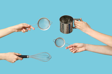 Female hands holding sieves with whisk on blue background