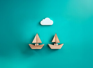 Two miniature wooden sailboats under a small white cloud against a teal background.  A simple, serene image suggesting travel, adventure, or teamwork.