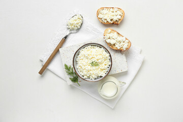 Bowl of fresh cottage cheese with dill and bread slices on white background