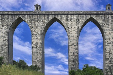 Fototapeta premium Urban highway passing under the 18th century historical Aqueduct of the Free Waters or Águas Livres Aqueduct, Lisbon, Portugal, Europe
