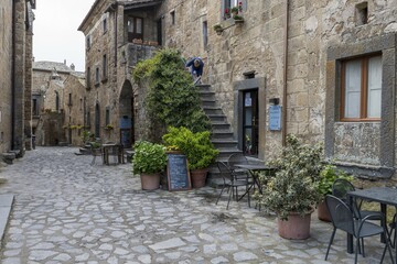 Old tufa buildings decorated with flowers in the hilltop village of Civita di Bagnoregio, Lazio, Italy, Europe