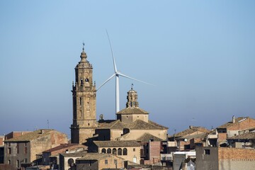 Wind power plant, in front of it an old small town with church tower, Catalonia, Spain, Europe