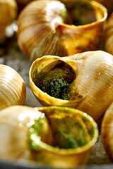 A dozen fresh snails cooked in a traditional French style, served in a small cast iron pan with...