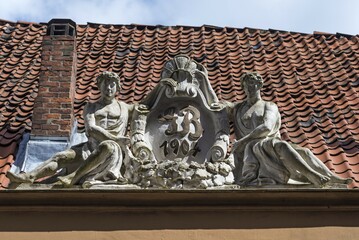 Art Nouveau figures on a roof with initials of the builder, Lübeck, Schleswig-Holstein, Germany,...