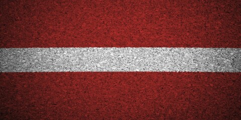 Fototapeta premium The Latvian flag painted on a cork board