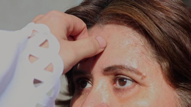 Priest places cross of ash on woman's forehead during Ash Wednesday