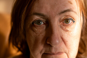 A worried senior woman at home, aging process. Close-up portrait.