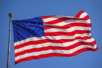 American flag, national flag, US-American flag blowing in the wind against a blue sky, USA, North America