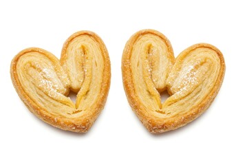 Fototapeta premium Two heart shaped pastries with golden flaky layers and a light dusting of powdered sugar isolated on a white background
