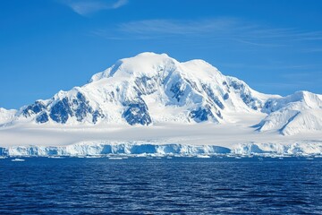 Majestic Antarctic Mountain Range and Ice Shelf under a Clear Blue Sky: A Stunning Landscape of Pristine Beauty.