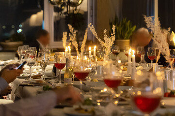 Elegant dinner party setting with guests enjoying food and conversation at night