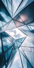 Abstract view of modern glass architecture showcasing geometric patterns and reflections of the sky and clouds.