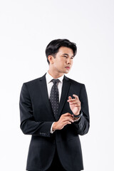 A man in a black suit and tie stands in front of a white background