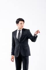 A man in a black suit and tie stands in front of a white background