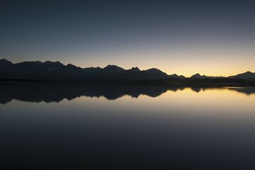 Evening light on the shore of Hopfensee Lake, Allgaeu Alps at back, Fuessen, Ostallgaeu region, Allgaeu, Bavaria, Germany, Europe