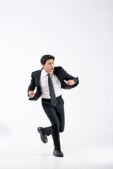 Obraz premium A man in a black suit and tie stands in front of a white background