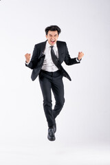 A man in a black suit and tie stands in front of a white background