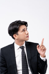 A man in a suit is looking at the camera with his finger on his forehead