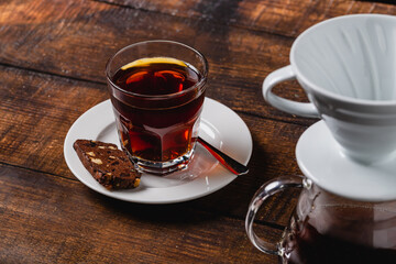 A cup of coffee and third generation pour over coffee brewing equipment on stone floor